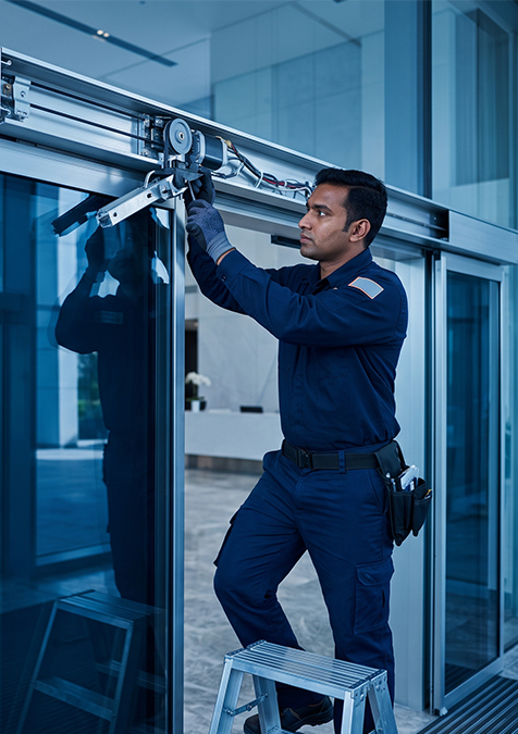 Dorcare technician installing an automatic sliding door in a commercial building lobby
